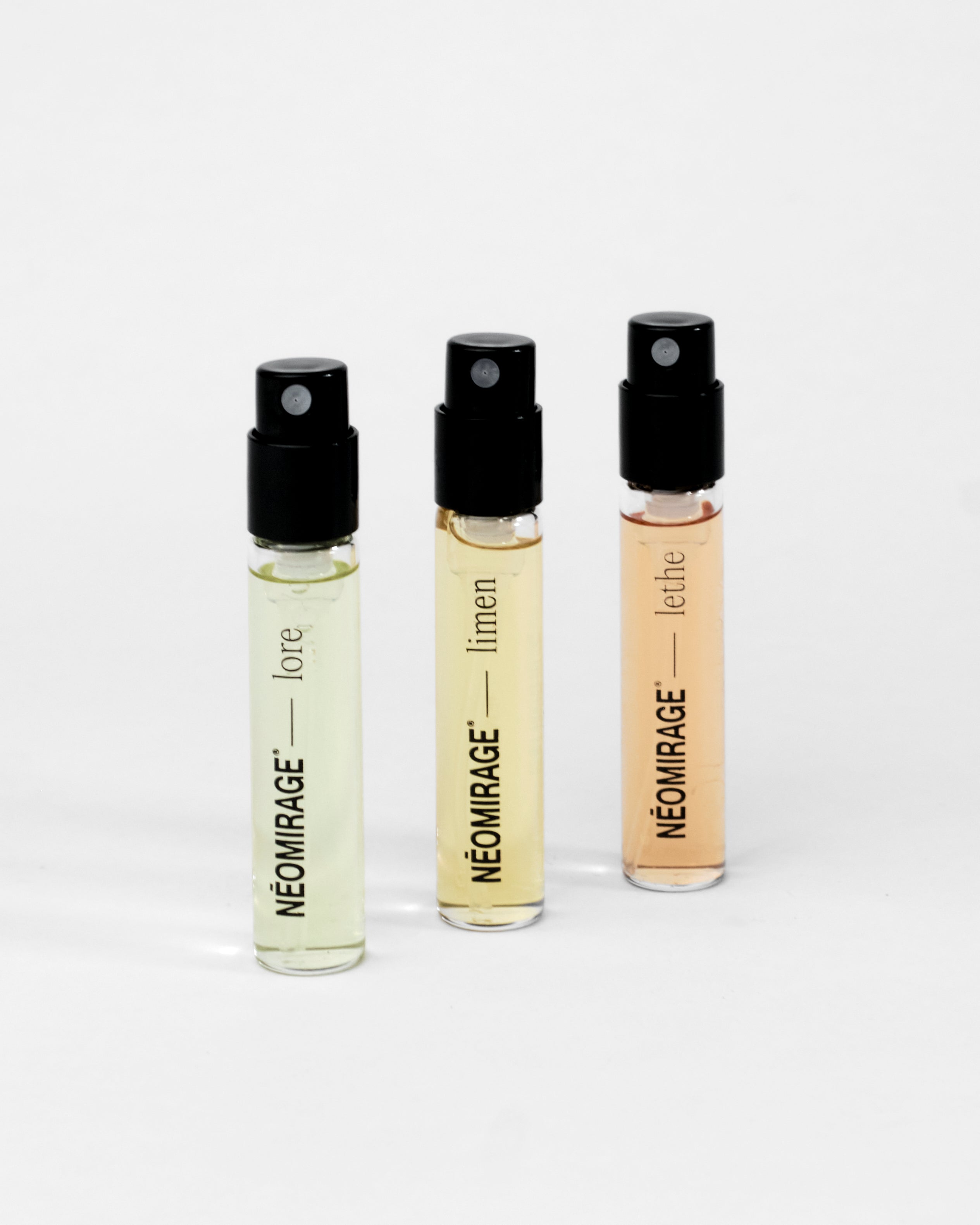 Three Neomirage perfume 3ml bottles with black caps on a white background
